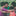 Young children gathered arm and arm in a circle outside