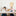 Two young kids sitting at a table cutting out paper crafts