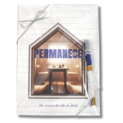 A Spanish-language Bible study workbook titled 'PERMANECE en MÍG' featuring a house-shaped window graphic showing a dining room interior. The workbook has a white wood-textured cover, a silver string bow at the top, and a blue, white, and gold pen tucked on the right side by CTA Christ to All and CTA Gifts.