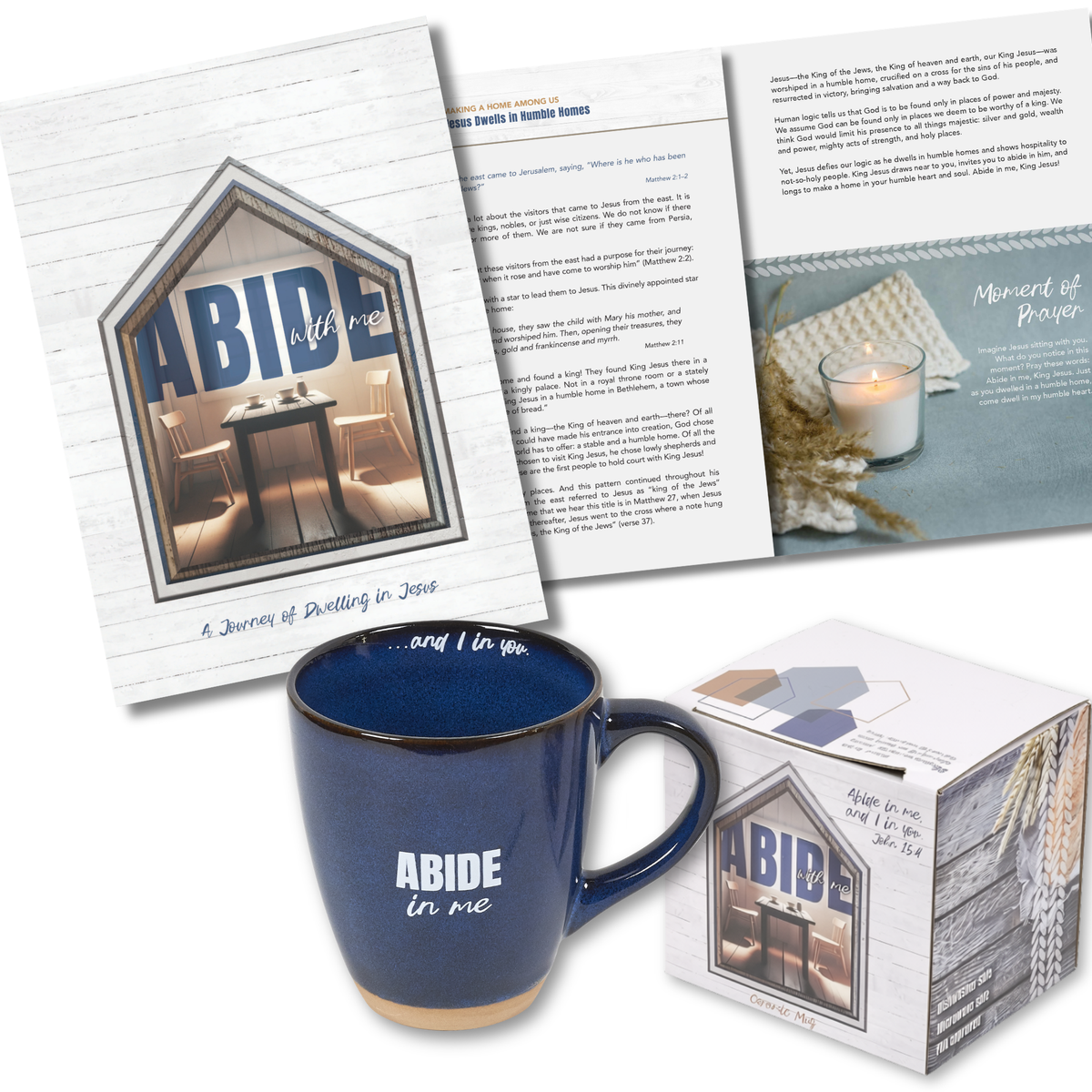 A coordinated product display featuring a dark blue ceramic mug with white 'ABIDE in me' text, a matching printed card or booklet with a house-shaped photo frame and text, an open printed page with paragraphs and a candle photo, and a white product box with the same house graphic. No person, animal, or real environment is present, so this is Product/Packaging by CTA Christ to All & CTA Gifts