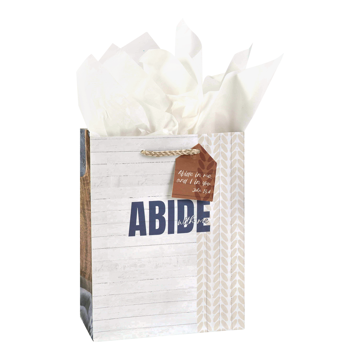 A personalized gift bag with a white wood-plank pattern, the word 'ABIDE' printed in navy blue, a brown hanging tag with white script, and white tissue paper fanned out from the top by CTA Christ to All and CTA Gifts.
