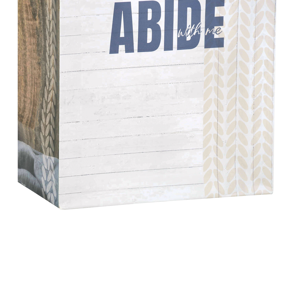 A decorative wall art print or canvas showing a rustic white wood plank background with the large text “ABIDE” in dark blue and smaller script text “with me.” Patterned side panels in beige and brown are visible along the left and right edges by CTA Christ to All and CTA Gifts.