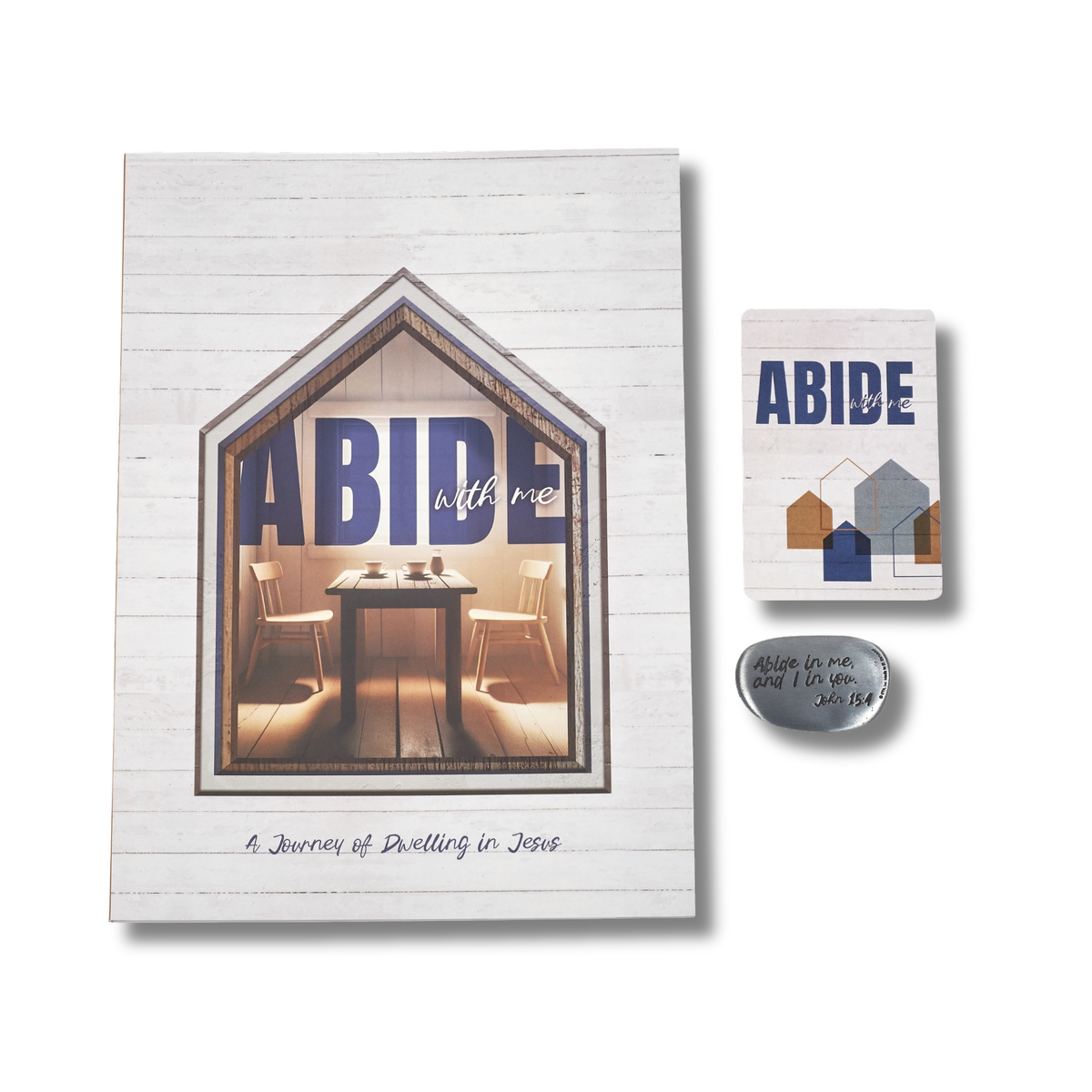 A coordinated set of three 'ABIDE' themed items on a white background: a large rectangular plaque with a house-shaped window showing a dining table and chairs, a smaller matching plaque with house graphics, and a small oval stone with the phrase 'Abide in me, and I will live in you. Jn 8:34' by CTA Christ to All & CTA Gifts.