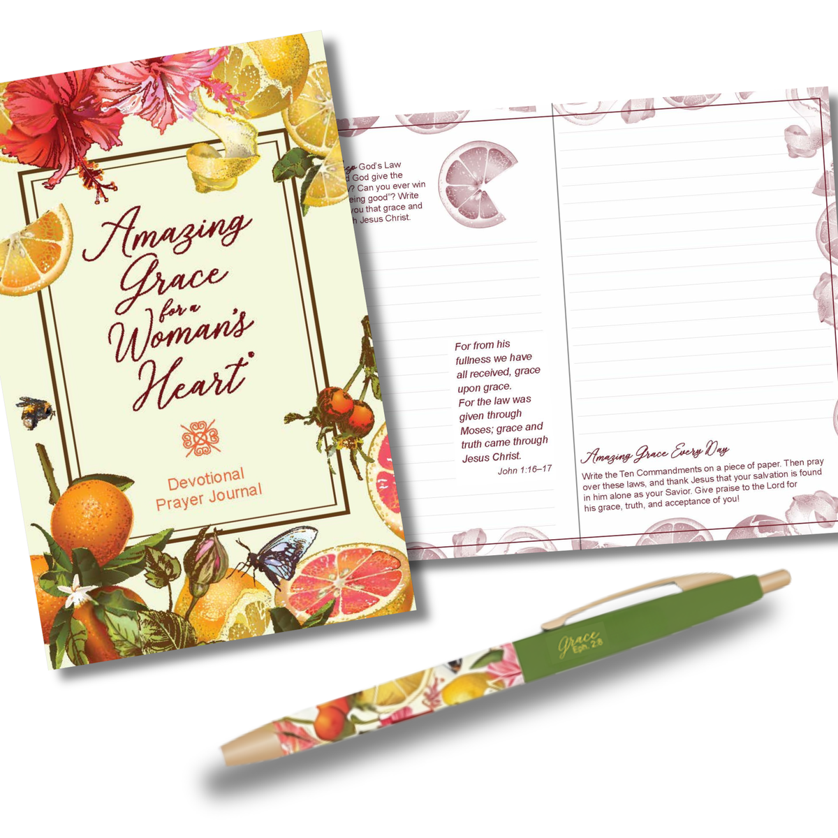 A floral devotional prayer journal with a matching lined inner page and a green pen, shown on a clean white background. The journal cover features citrus and fruit illustrations with the title 'Amazing Grace for a Woman's Heart' and the brand name 'Devotional Prayer Journal' visible by CTA Christ to All & CTA Gifts.