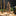 Wooden Christmas tree home decor with nativity scene on a wooden table with candles and greenery.