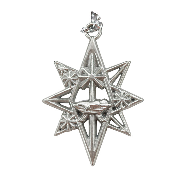 Silver-tone Christmas ornament in the shape of an eight-pointed star featuring an openwork design with decorative floral accents and a nativity-inspired scene at the center. The ornament includes a radiant star above a manger and hangs from a silver loop, making it a Christian Christmas keepsake suitable for holiday decorating, church gifts, outreach events, and seasonal ornament collections by CTA Christ to All and CTA Gifts.