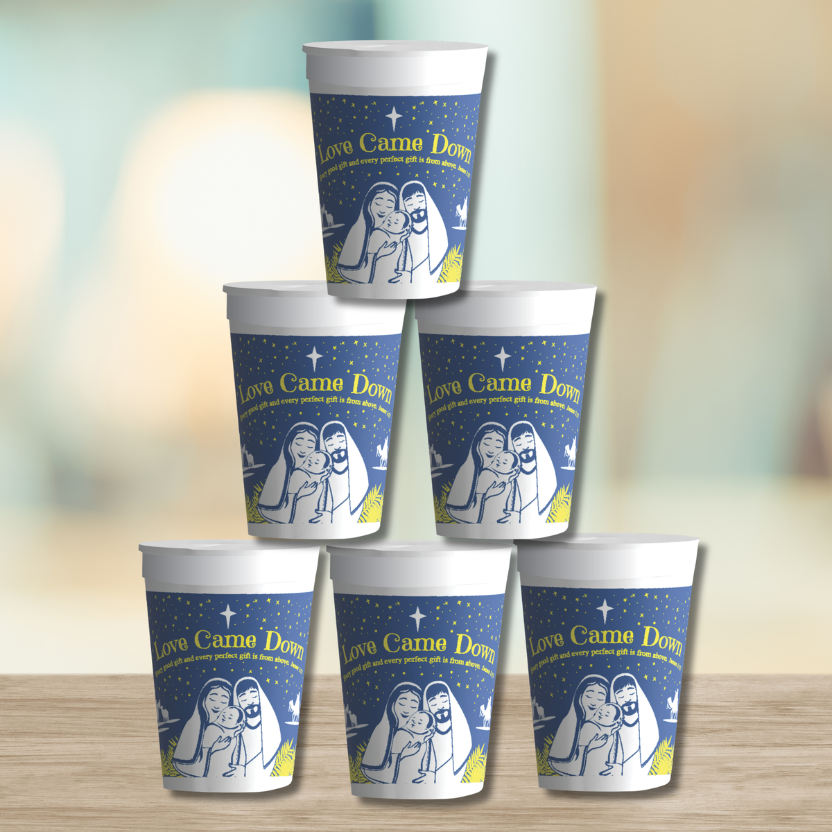 Five stacked disposable cups featuring the “Love Came Down” Christmas design with a nativity illustration of Mary, Joseph, and baby Jesus beneath a star-filled night sky. Blue cups with white and gold accents are displayed in a pyramid arrangement on a tabletop. Ideal for church Christmas events, holiday gatherings, nativity-themed celebrations, refreshments, and seasonal ministry outreach by CTA Christ to All and CTAKids.