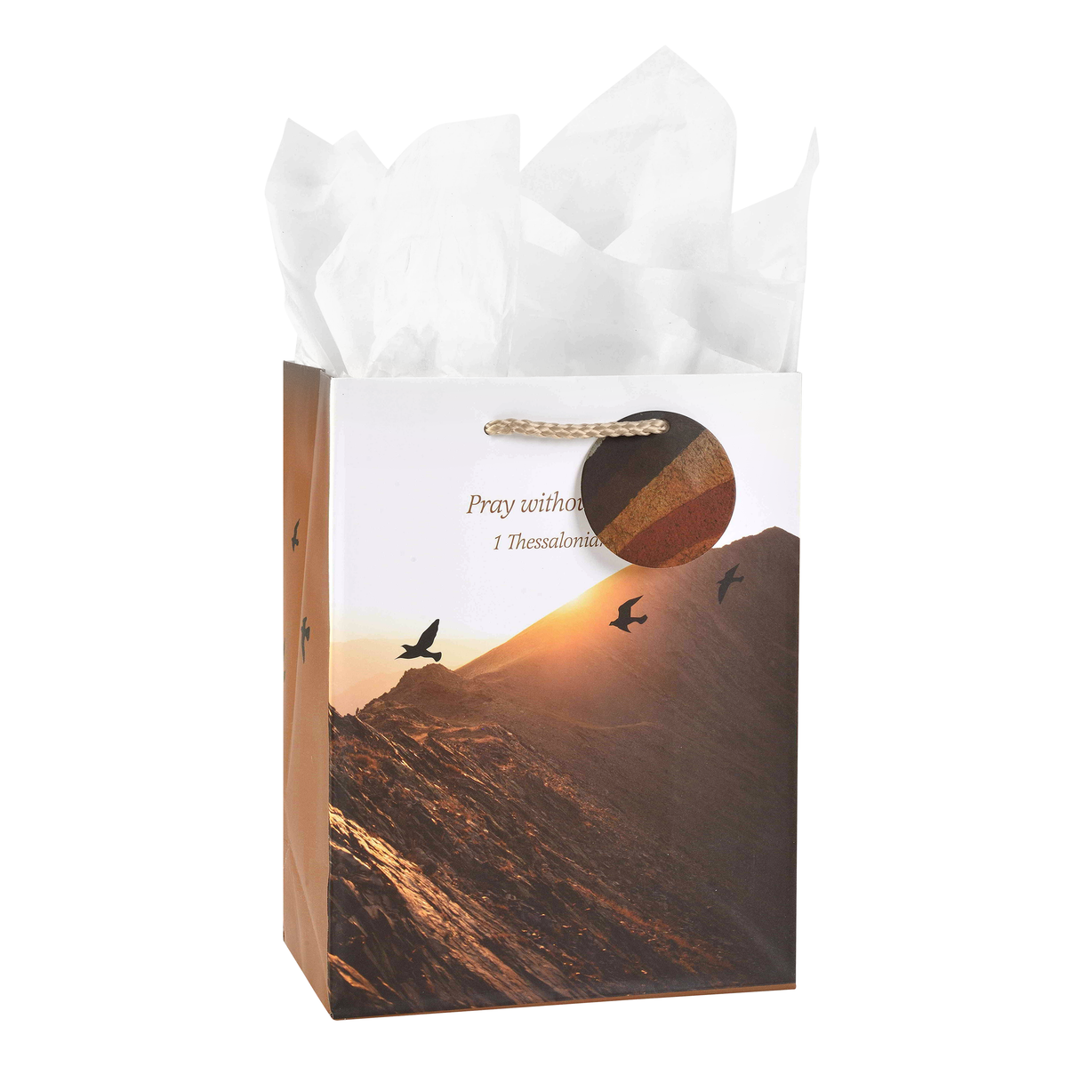 Gift bag with mountain and bird design, containing white tissue paper by CTA Christ to All and CTA Gifts.