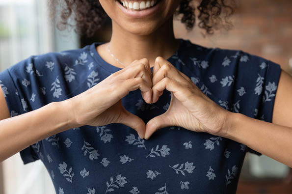 Woman making heart shape with her hands in appreciation