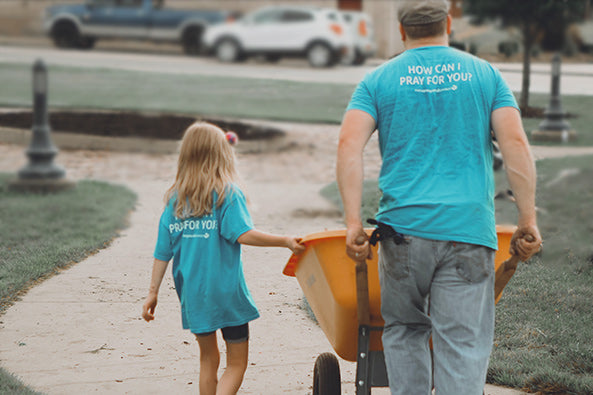 Man and daughter working together as volunteers doing yardwork