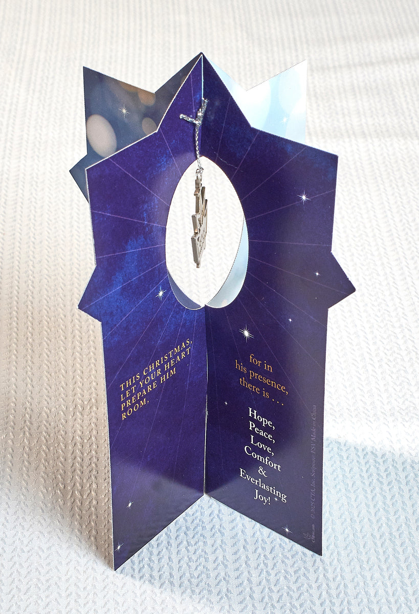 Blue Christmas card with text and a silver ornament on a white textured background