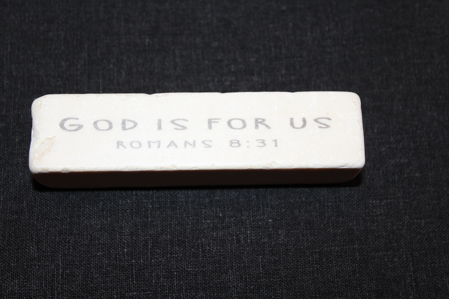 White stone with 'God is for us Romans 8:31' text on a black background