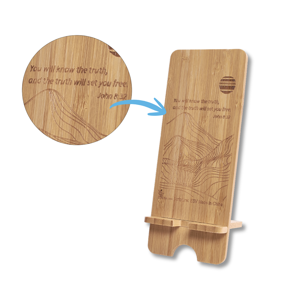 A personalized bamboo phone stand with engraved topographic map lines and the Bible verse John 8:32. A circular inset shows a close-up of the engraved text, with a blue arrow pointing to the stand on a white background by CTA Christ to All and CTA Gifts.