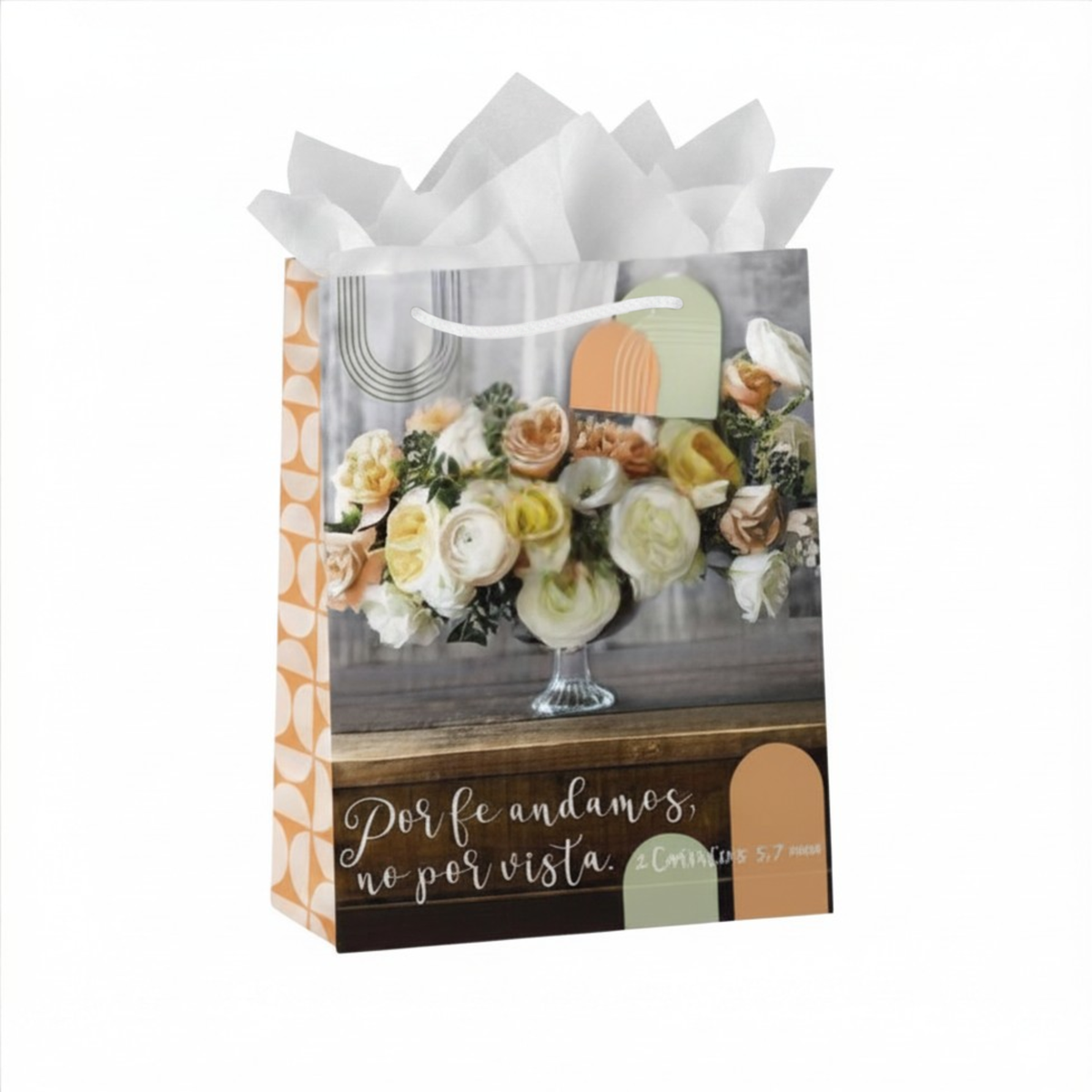A decorative gift bag with white tissue paper at the top, featuring a floral arrangement print and the Spanish phrase 'Por fe andamos, no por vista. Caminamos 5:7' on the front, set against a plain white background by CTA Christ to All and CTA Gifts.