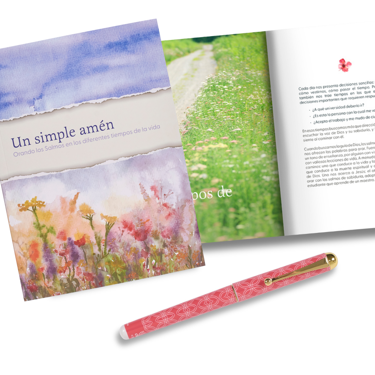 A pink patterned pen with gold accents lies on a white background in front of an open Spanish-language book or booklet. The book cover and interior pages feature watercolor floral and green landscape artwork by CTA Christ to All & CTA Gifts.