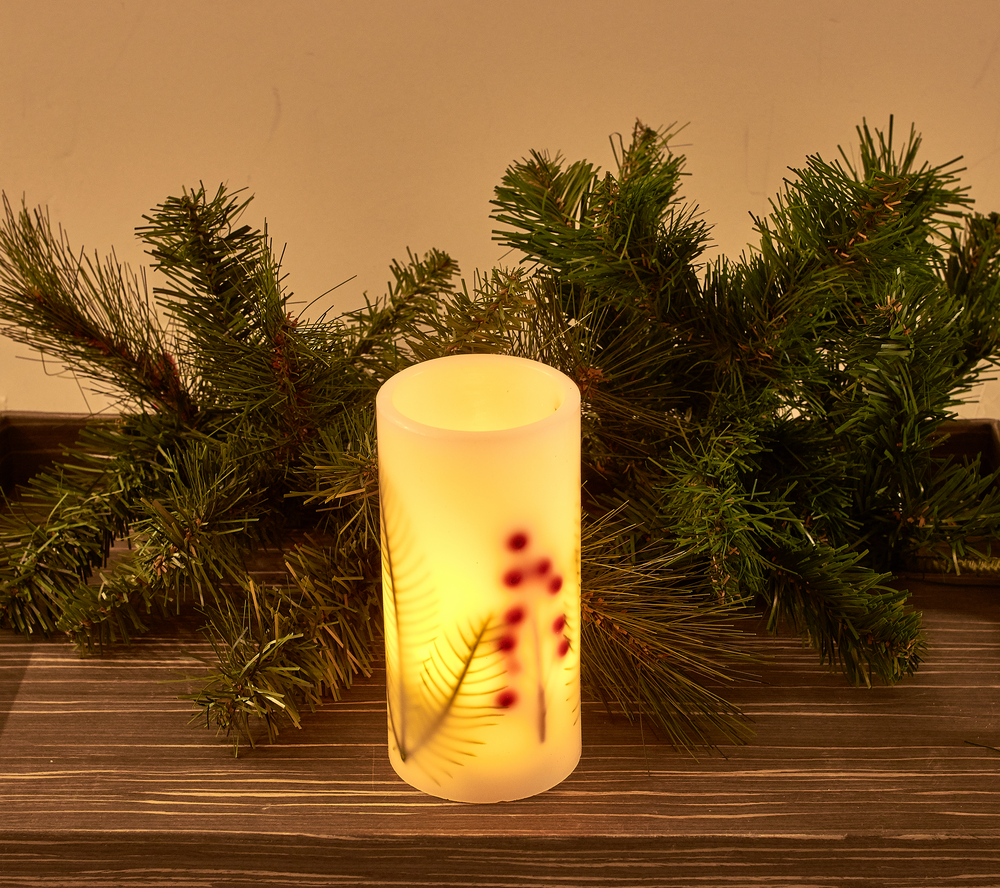 LED Christmas candle shown glowing on shelf